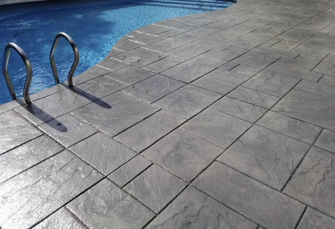 Stamped concrete pool deck with slip-resistant texture surrounding a residential pool
