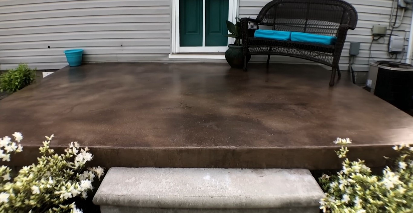 Stained concrete patio with entry steps and landscaping at a residential home